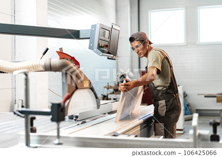 Male carpenter using some woodworking tools for his work in a factory Male carpenter using some woodworking tools for his work in a factory 106425066