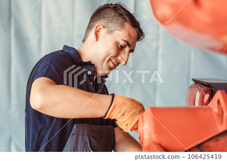 Technician for farm machinery doing maintenance work Technician for farm machinery doing maintenance work 106425419