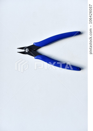Forceps with a blue handle on a white background. A tool for repairing electronics. 106426087