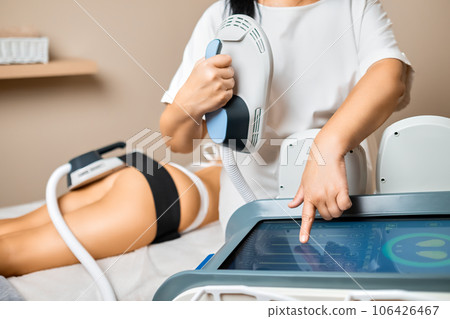 A specialists hands deftly prepare body sculpting equipment for the client's buttocks, embarking on a procedure to enhance the client's aesthetic. A specialists hands deftly prepare body sculpting equipment for the client's buttocks, embarking on a procedure to enhance the client's aesthetic. 106426467