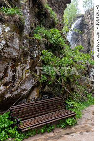 En empty bench stands near the trail 106426549
