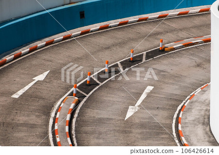two lane road curve with direction arrows on asphalt 106426614