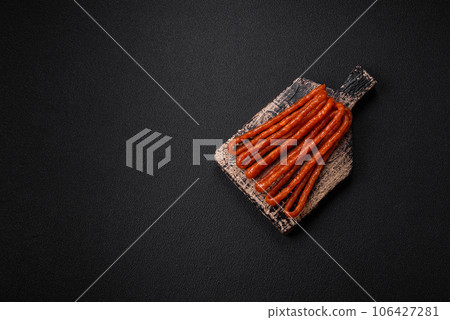 Delicious thin smoked hunting sausages with salt, spices and herbs Delicious thin smoked hunting sausages with salt, spices and herbs 106427281