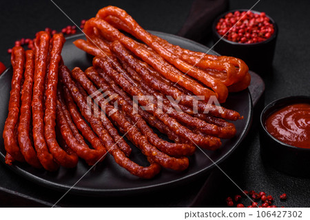 Delicious thin smoked hunting sausages with salt, spices and herbs 106427302