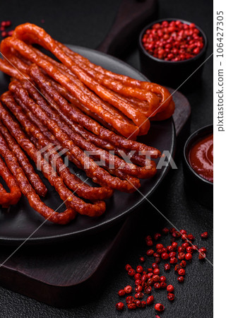 Delicious thin smoked hunting sausages with salt, spices and herbs 106427305