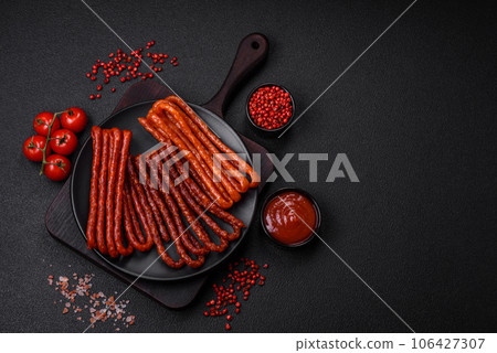 Delicious thin smoked hunting sausages with salt, spices and herbs 106427307