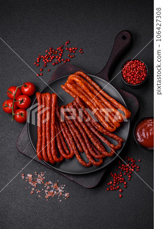 Delicious thin smoked hunting sausages with salt, spices and herbs 106427308