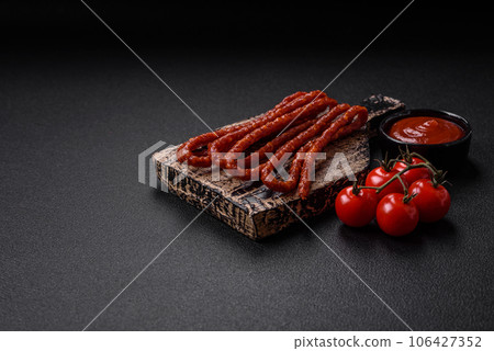 Delicious thin smoked hunting sausages with salt, spices and herbs 106427352