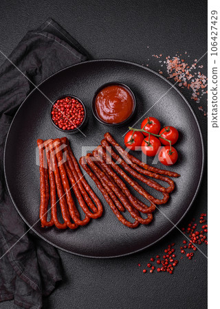 Delicious thin smoked hunting sausages with salt, spices and herbs 106427429