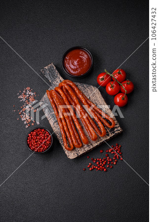 Delicious thin smoked hunting sausages with salt, spices and herbs 106427432