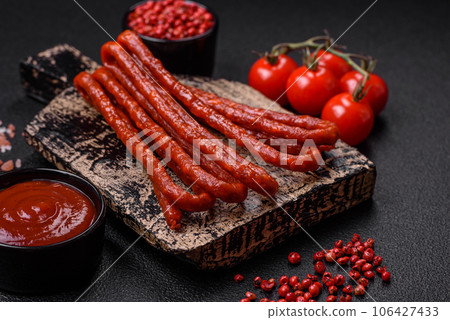 Delicious thin smoked hunting sausages with salt, spices and herbs 106427433