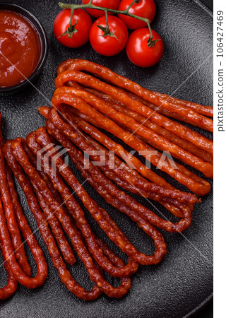 Delicious thin smoked hunting sausages with salt, spices and herbs 106427469