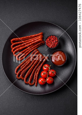 Delicious thin smoked hunting sausages with salt, spices and herbs 106427476