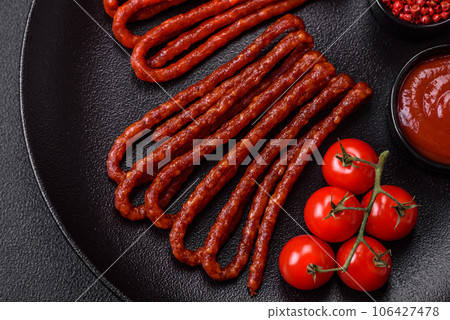 Delicious thin smoked hunting sausages with salt, spices and herbs 106427478