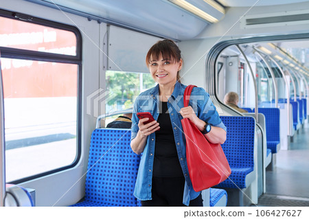 Woman is a passenger inside an electric train car 106427627