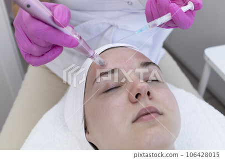 Cosmetologist Applying Peeling For Mesotherapy Injection With Dermapen On Face, Forehead Area Of Young Woman For Rejuvenation In Spa Saloon. Patient Getting Needle Mesotherapy, Skincare. Horizontal. Cosmetologist Applying Peeling For Mesotherapy Injection With Dermapen On Face, Forehead Area Of Young Woman For Rejuvenation In Spa Saloon. Patient Getting Needle Mesotherapy, Skincare. Horizontal. 106428015