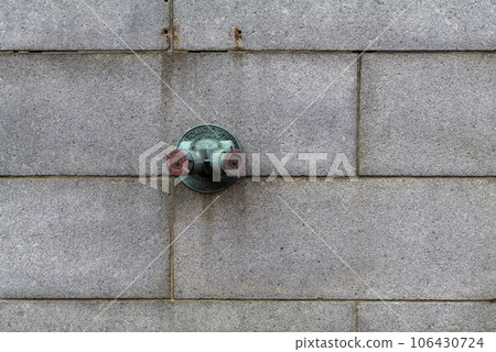 Fire hydrant water pipe, mounted in a building wall. Manhattan USA 106430724