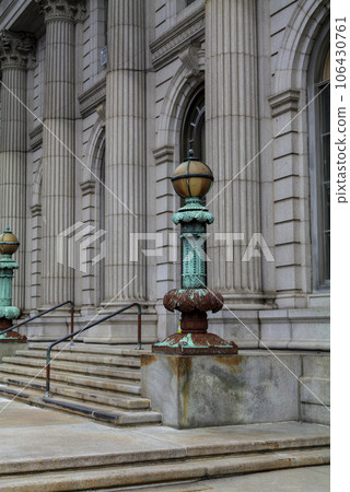 Cast iron, forged antique street lamp with paint peeling off over time in front of the City Hall Cast iron, forged antique street lamp with paint peeling off over time in front of the City Hall 106430761