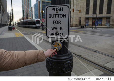 Young girl pressing button to walk across Train crosswalk in Jersey City New Jersey USA 106430811