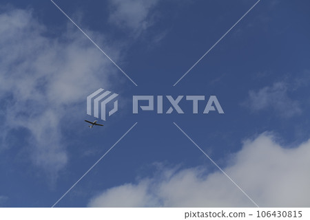 Small white cessna single propeller plane flying in a clear blue sky  106430815