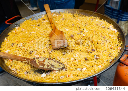 Cooking the Valencian dish Fideua de Marisco Cooking the Valencian dish Fideua de Marisco 106431844