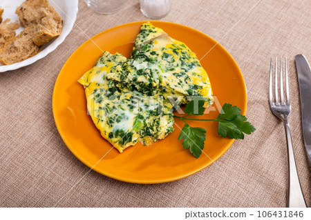 Omelet with spinach, decorated with sprig of parsley, slices of bran bread Omelet with spinach, decorated with sprig of parsley, slices of bran bread 106431846