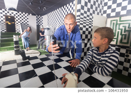 Family tries to get out of the escape room, stylized as a chessboard 106431950