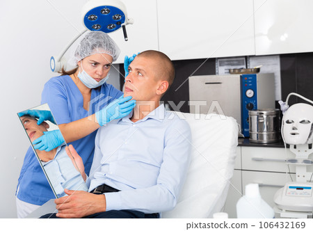 Woman beautician consulting male client before facial treatment Woman beautician consulting male client before facial treatment 106432169