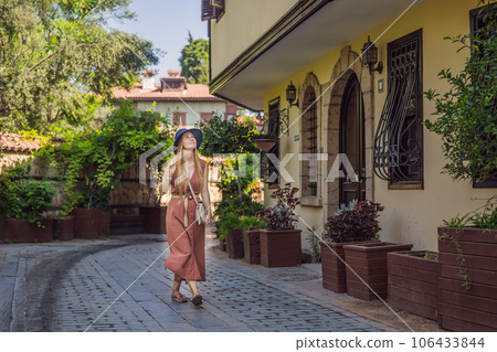 Happy woman tourist on background of old street of Antalya. female tourist traveler discover interesting places and popular attractions and walks in the old city Kalechi of Antalya, Turkey. Turkiye 106433844