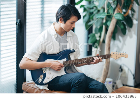 在家練習吉他的年輕人 在家練習吉他的年輕人 106433963