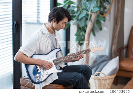 Young man practicing guitar at home 106433965