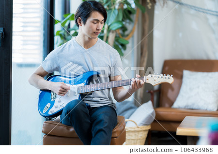 Young man practicing guitar at home Young man practicing guitar at home 106433968