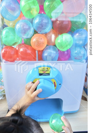 A child spinning a gacha gacha A child spinning a gacha gacha 106434500