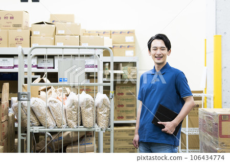 Young man working in a warehouse 106434774