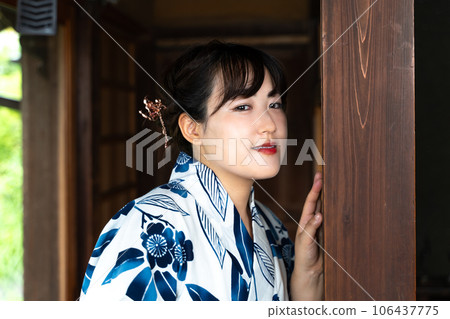 一個穿著浴衣的女人在門廊上擺姿勢 一個穿著浴衣的女人在門廊上擺姿勢 106437775