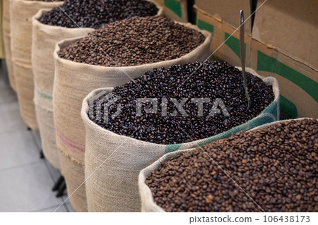 Freshly roasted coffee beans with a metal scoop, in jute sacks. Close-up with an open coffee bag. Arabic coffee beans in bag. 106438173