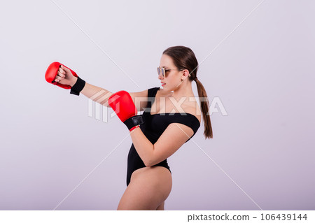 Seductive female boxer with athletic beautiful figure in black swimsuit gloves on gray background 106439144