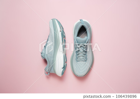 New light blue green female modern running shoe on pink background. Stylish monochrome shoes for active people that incorporate new health technology. Top view 106439896