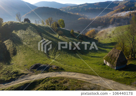 Aerial view of autumn countryside farm, with abandoned wooden houses and barns in the mountains 106440178