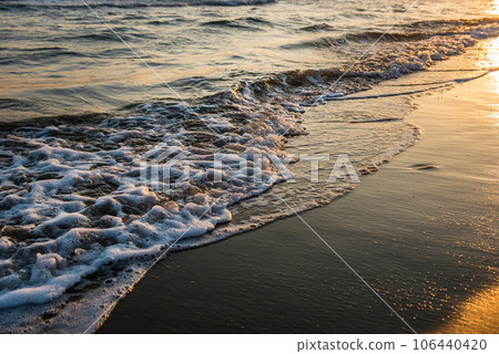Waves approaching sandy beach during sunset Waves approaching sandy beach during sunset 106440420