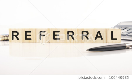 referral word assembled from wooden cubes next to a calculator, pen and notepad referral word assembled from wooden cubes next to a calculator, pen and notepad 106440985