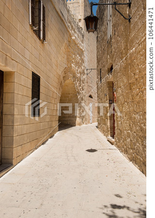 Narrow medieval street with stone houses in Mdina, Malta Narrow medieval street with stone houses in Mdina, Malta 106441471
