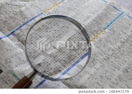 Newspaper TV section and magnifying glass with glass lens Newspaper TV section and magnifying glass with glass lens 106441579