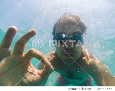Underwater view of a man swimming in the sea Underwater view of a man swimming in the sea 106442337