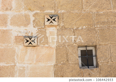 Ventilator on a stone wall. Maltese cross 106442933
