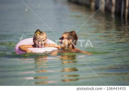 mother and daughter swimming in the sea mother and daughter swimming in the sea 106443435