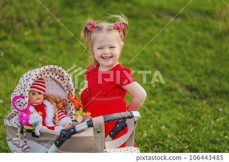 baby with toy stroller and doll 106443485