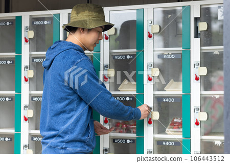 A man buying vegetables and fruits from a vending machine 106443512