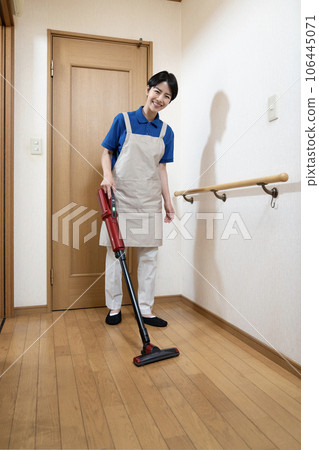 Woman vacuuming flooring Woman vacuuming flooring 106445071