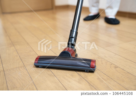 一個女人用吸塵器吸地板的腳 一個女人用吸塵器吸地板的腳 106445108